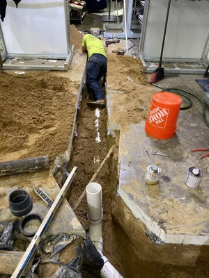 Indoor trench plumbing repair with new PVC pipe